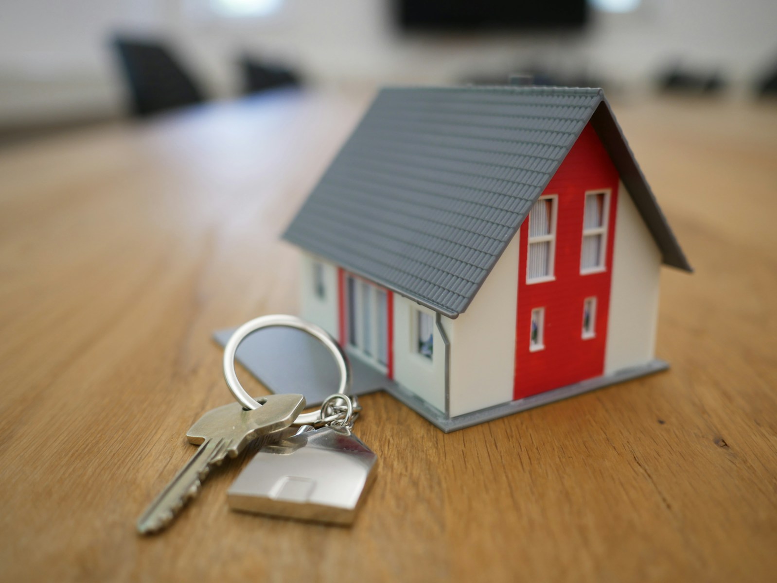 white and red wooden house miniature on brown table with homeowners insurance